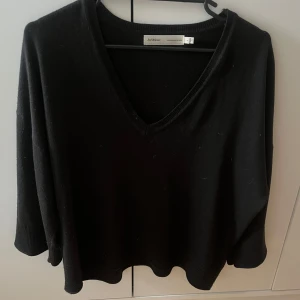 Svart tröja från In wear  - Säljer en stilren svart tröja från in wear med v-ringning och trekvartsärmar. Perfekt för en avslappnad look. Passar bra till både jeans och kjol. Kom privat för fler frågor! 