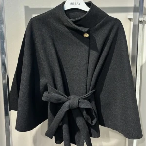 Svart kappa från Missay - Svart kappa från Missay med knytband i midjan och en knappdetalj vid halsen! Den populära slutsålda capen! (Inte mina bilder, kom privat för fler) super bra skick! 🤌🏼 Skriv endast om du är intresserad av att köpa 👌🏼