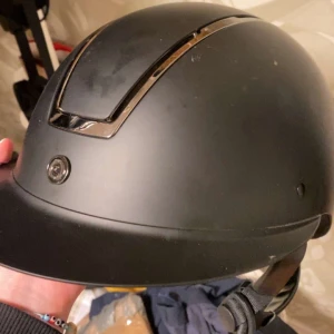 Svart ridhjälm från Horze - Snygg svart hjälm med stilrena metalliska detaljer. Perfekt för ridning eller bara för att ha säkerhet i stallet. Inga större skador, bra skick. Köpt för 1 790kr. Justerbar för att passa alla slags huvudformer. 💕✨