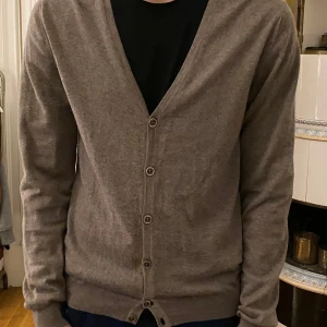Grå-brun kofta från Stenströms - Grå-brun kofta från Stenströms med knappar framtill. Använd endast ett fåtal gånger, men har ett litet, litet hål vid den översta knappen som man kan se på den 3:e bilden. Nypris låg på 3000kr
