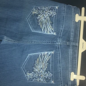 ND weekend jeans- broderade bakfickor - Blå jeans med broderade fickor inköpta i USA stl 12 motsvarar ca 42/44, avklippta och lite slitna längst ner, annars i toppskick.