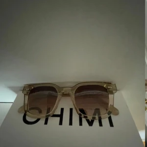 Transparenta solglasögon från Chimi - Snygga solglasögon från Chimi med transparenta bågar och bruna tonade linser. Den rektangulära formen ger en modern look. Perfekta för soliga dagar och en stilren accessoar till din outfit.