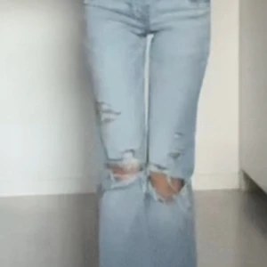 Ljusa jeans med slitningar - Snygga lågmidjade ljusblå jeans med hål på knäna och låren. Innerbredden är 70cm och midjemåttet är 31cm 