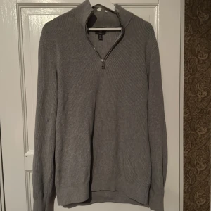 Grå half zip - Snygg grå ribbad tröja med dragkedja vid halsen. Perfekt för kyligare dagar med sin långärmade design. Enkel och stilren, passar till det mesta. 