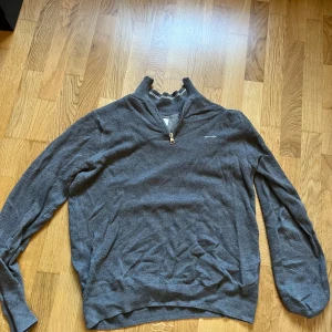 Grå tröja med dragkedja från GANT - Snygg grå tröja från GANT med dragkedja vid halsen. Skick 9/10 storlek M
