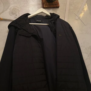 Svart jacka från J.Lindeberg - Snygg svart jacka från J.Lindeberg med quiltad design. Jackan har en dragkedja framtill och är perfekt för kyligare dagar. Den har en stilren look och passar bra till olika outfits.