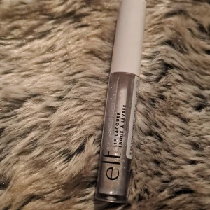 Läppglans från e.l.f. i nyansen Bubbles - Snyggt läppglans från e.l.f. i nyansen Bubbles. Glanset har en skimrande finish och kommer i en smidig tub med vit kork. Perfekt för att ge läpparna en glansig look.