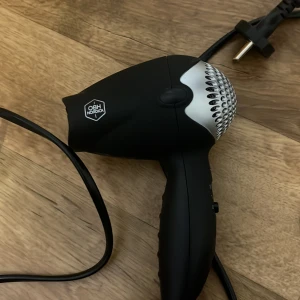 Liten hårfön från OBH NORDICA - Säljer en kompakt och smidig hårfön från OBH Nordica. Perfekt för resor eller mindre utrymmen! Hårfönen har två värmelägen och en kraftfull prestanda trots sin lilla storlek. Ergonomisk design som ligger bekvämt i handen. Fungerar utmärkt och är i mycket bra skick 