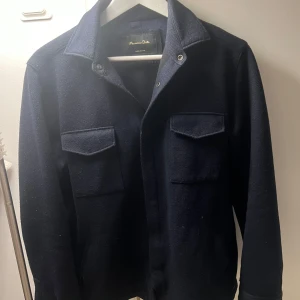 Mörkblå overshirt från Massimo Dutti - Snygg mörkblå overshirt från Massimo Dutti med klassisk krage och två bröstfickor. Perfekt för lager-på-lager-stil. Passar bra till både vardag och mer uppklädda tillfällen.storlek M. Pris går att diskutera vid snabb affär!