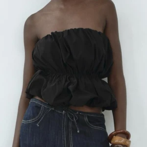 Svart tubtopp - Snygg svart tubtopp med volangdetaljer. Aldrig använd då den inte kommit till andväning då jag har en liknande🥰 skriv för egna bilder!!