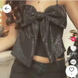 Svart zara topp med rosett - Trendig svart topp med en stor glittrig rosett framtill. Prislappen är kvar då jag tänkte ha den på jul men kom inte till användning💓 ny skick! Skriv för egna bilder!