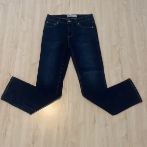 Levis 511 Slim Jeans - Snygga mörkblå Levis 511 Slim jeans med klassisk femficksdesign och gul kontrastsöm. Perfekta för en stilren look med en smal passform som sitter snyggt. Tillverkade i slitstarkt denim.