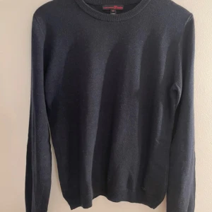 Svart tröja från Tom Tailor Denim - Säljer en stilren svart tröja från Tom Tailor Denim. Tröjan är tillverkad i en mjuk blandning av bomull och viskos, vilket gör den bekväm och lätt att bära. Den har långa ärmar och en klassisk rund halsringning.