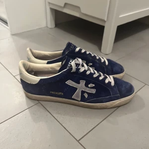 Blå mocka sneakers från Premiata (44) - Snygga blå sneakers från Premiata. Vill du vara GRISH är detta dem rätta skorna för dig. Skorna är i storlek 44, hör av er vid frågor. Box och kort ingår. Pris kan diskuteras 