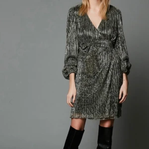 Glittrig omlottklänning med knytband - Jätte fin glitrig klänning i nyskick, perfekt till nyår eller andra fester, nypris 1500 kr pris kan diskuteras 