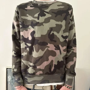 Camouflage tröja från Valentino - Säljer en snygg camouflage tröja från Valentino. Tröjan har ett klassiskt mönster i gröna och bruna toner. Perfekt för en avslappnad stil.