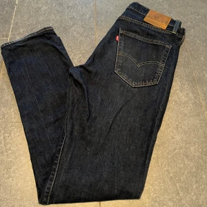 Mörkblå 502 jeans från Levi's W32 L34 - Säljer ett par stilrena mörkblå 502 Levis jeans med rak passform. Mycket bra skick, inga synliga defekter. Storlek L32 W 34. Ytterben: 107 cm, innerbenet: 82 cm, midja: 43 cm, benöppning: 19 cm. Längden passar mig som är ca 187 cm.                 Pris kan diskuteras! 