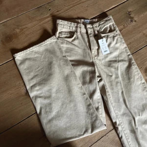 Beige jeans från Boulevard - Snygga beige jeans från Lager157 i modellen Boulevard. Storlek XXS. Jeansen är i en vid modell och perfekta för en stilren look. Dem är helt oanvända och har prislappen kvar. Nypris 300kr