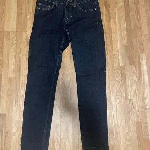 Mörkblå jeans från Tiger of Sweden - Snygga mörkblå jeans från Tiger of Sweden med klassisk femficksdesign och kontrasterande sömmar. Perfekta för en stilren look. Aldrig använda💕 nypris: 1 499kr. Passar mig som har storlek s 