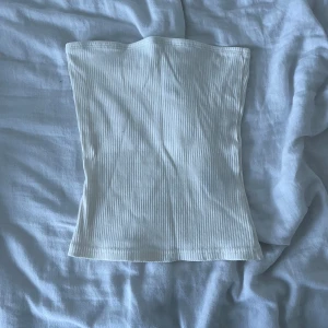 Vit ribbad tubtopp från H&M Divided - Säljer en stilren vit ribbad tubtopp från H&M Divided. Perfekt för sommardagar och enkel att matcha med olika outfits. Toppen är i storlek XS och har en bekväm passform.