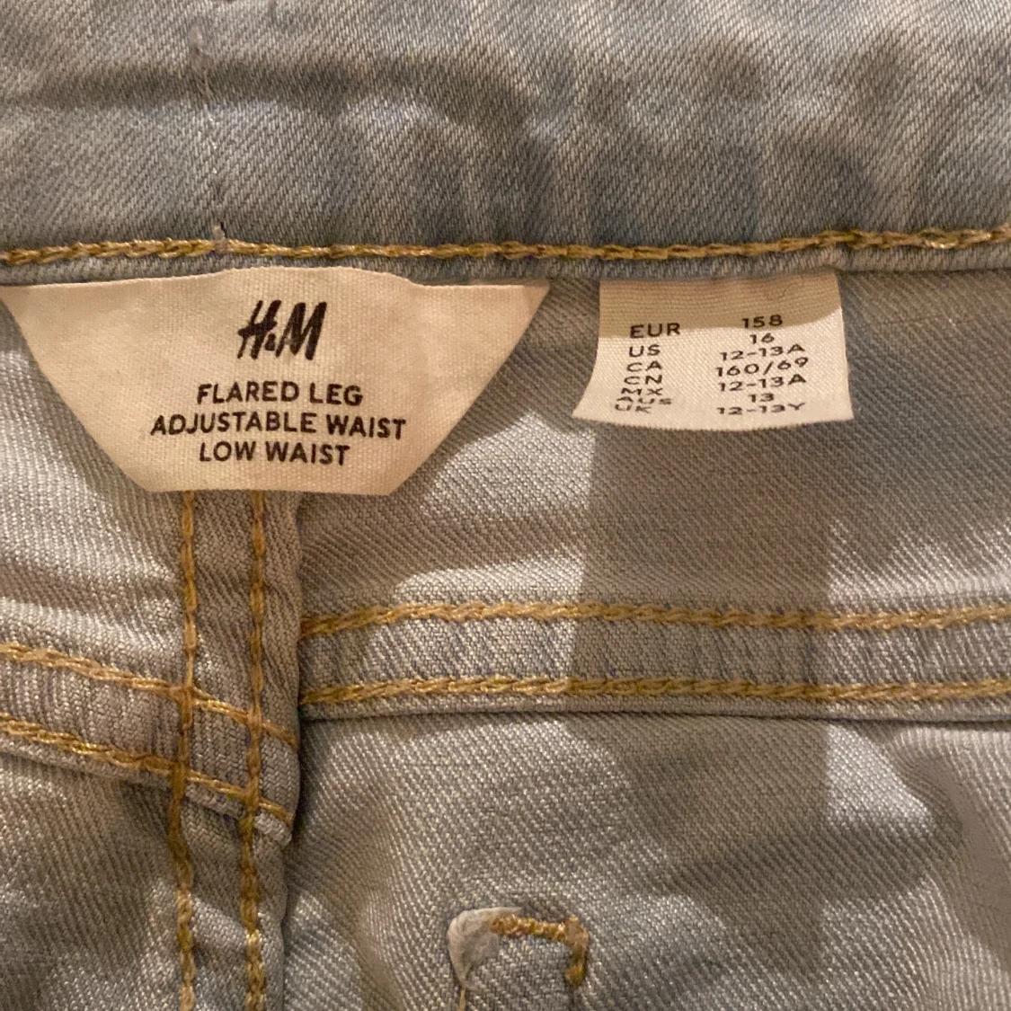 Ljusblå byxor som är low waist och boot cut - 91