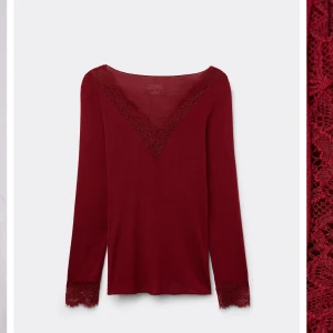 Vinröd långärmad topp från Intimissimi - Säljer en  vinröd topp från Intimissimi med spetsdetaljer vid v-ringningen och ärmsluten. Det är inte samma färg som på den första bilden utan lite mer vinrött. Tröjan är i jättebra skick och priset går att diskutera ❤️