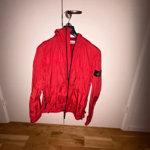 Röd vindjacka från Stone Island - Säljer en snygg röd vindjacka från Stone Island. Köpte denna jacka förra sommaren på nk Stockholm, endast testad och kvitto finns!