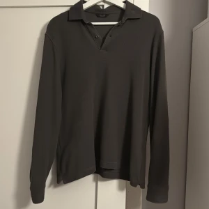 Brun långärmad pikétröja från Massimo Dutti - Säljer en stilren brun långärmad pikétröja från Massimo Dutti. Tröjan har en klassisk krage och knappar vid halsen, perfekt för en avslappnad men ändå elegant look. En av mina favorit tröjor men behöver sälja den nu för att den har blivit för liten. En super snygg tröja som är i ett bra skick.  Bara att höra av er vid intresse! :) 