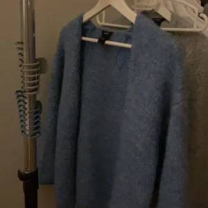 Blå stickad kofta från Lindex - Säljer denna otroligt fina populära stickade tröjan i blå som även är i storlek xs/s som alla bär nu, dom brukar oftast sätta en klämma i koftan, den är heeelt nyköpt asså pårikgit bara använt en gång helt nytt skick anledningen varför jag vill sälja är för att jag tycker inte jag passar in i den färgen då ja mest bär basic färger som vit svart och grå❤️ denna koftan låg på 400 kr så väldigt bra pris skulle jag säga eftersom den är helt ny😇