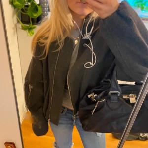 Grå Zara bomberjacka - Snygg grå bomberjacka med dragkedja och ribbade muddar. Perfekt för en casual look och passar bra till jeans. Jackan har en klassisk design med långa ärmar och en bekväm passform.