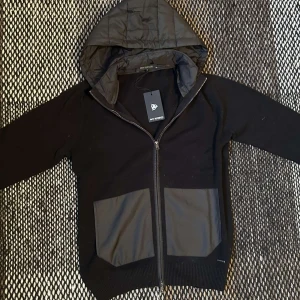 Cardigan jacka(HELY NY) - Tja, ja säljer nu denna helt nya cardigan jackan med tags kvar. Den funkar perfekt att ha som jacka utomhus men även cardigan inomhus då luvan är avtagbar. Modellen är 174 väger 56. Nypris är ungefär 1700 men ja säljer för 899 få passa på! Har en exakt likadan i profilen till. Hör sv er vid funderingar. MVH