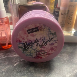 Always Believe Body Butter från Sence - Mjukgörande kroppssmör med doft av körsbärsblom och lilja. Kommer i en lila burk med ett färgglatt mönster på locket. Innehåller 200 ml.