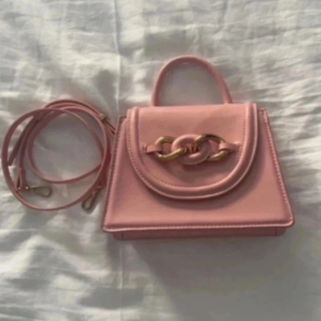 Rosa handväska med kedjedetalj