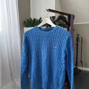 Blå kabelstickad tröja från Gant - Säljer en blå kabel stickad tröja ifrån gant i stl 15 år. Den är i mycket fint skick och kan skicka överallt! Hör gärna av dig vid ev frågor!