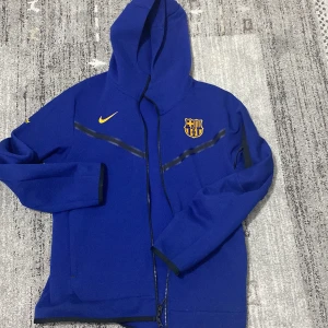 Blå Nike jacka med FCB-logga - Säljer en blå Nike jacka med fc Barcelona -logga på bröstet. Helt ny oanvänd, bra skick