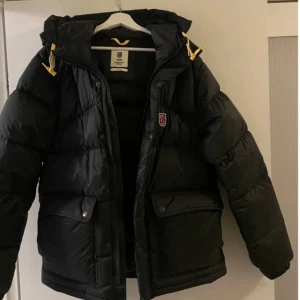 Svart dunjacka från Fjällräven - Säljer en svart dunjacka från Fjällräven. Expedition down lite. Storlek XXS. Mkt bra skick inga hål eller skavanker. 