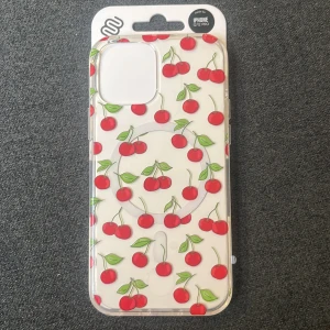 Mobello iPhone 12/12 Pro skal med körsbärsmönster - Snyggt och skyddande iPhone 12/12 Pro skal från Mobello, genomskinligt med körsbär. Skalet är MagSafe-kompatibelt och har skyddande kanter samt en slimmad profil. Aldrig använd, säljer endast för att jag råkade köpa till fel iPhone model 😓