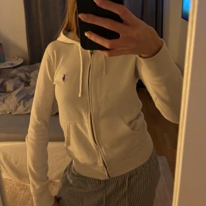 Vit zip hoodie från Ralph Lauren - Säljer en stilren vit zip hoodie från Ralph Lauren med dragkedja och luva. Välanvänd men absolut inget som syns. Stl xs. Kontakta mig vid fler bilder eller vid intresse!💕💕
