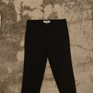 Kostymbyxor - Eleganta svarta kostymbyxor från Promod med en klassisk passform. Perfekta för en formell stil. Byxorna är jätte bekväma och har ett skönt material. Passar med allt och är max använda 2-3 gånger