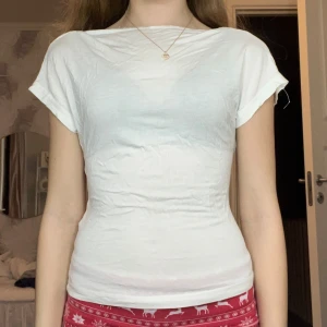 Vit topp med öppen rygg - Säljer en stilren vit topp med korta ärmar och en elegant öppen rygg. Perfekt för en somrig look eller en utekväll. Toppen har en smickrande passform och är tillverkad i ett mjukt material. Den är knappt använd och den är pyttelite genomskinlig. Jag har även sytt dit en liten tråd längst upp vid ryggen så den inte ramlar ner😊Kostade 40 kr så jag säljer den för halva priset! 😍