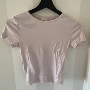 Ljusrosa t-shirt - Säljer en enkel och stilren ljusrosa t-shirt med rund halsringning. Perfekt basplagg för alla tillfällen. Kortärmad och i mjukt material.