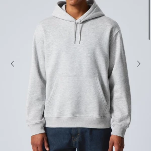 Grå hoodie - Säljer en stilren grå hoodie med känguruficka och justerbar huva. Perfekt för en avslappnad look. Passar bra till jeans eller joggers.
