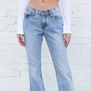 LjusBlå bootcut lågmidjade low waisted jeans - Brandy Melville lågmidjade jeans i bootcut stil. Säljs ej längre. Tror modellen heter Lara. Har sytt på en extra knapp så de skulle passa min midja, vanliga knappen är W24-W25 skulle jag säga, med min extra knapp funkar de för dem som har W24 eller mindre. 