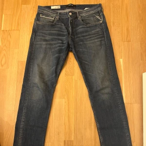 Replay jeans 33x32 - Snygga Replay Grover jeans i mörkblå tvätt.  Modellen är rak med regular fit.  Detaljer inkluderar läderlapp baktill och diskreta fickdetaljer.  Perfekt för både vardag och fest. Storlek 33/32
