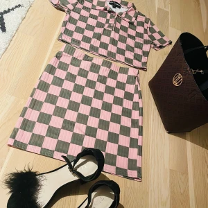 Rutig överdel och kjol från New Girl Order - Snygg rutig kjol i rosa och grön från New Girl Order med en normal passform och är perfekt för en trendig look. Matcha med den tillhörande toppen för en komplett outfit.