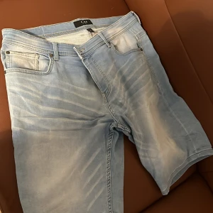 Ljusblå jeansshorts från Smog - Säljer ett par ljusblå jeansshorts från Smog. De har en klassisk femficksdesign och stängs med dragkedja och knapp. Perfekta för en avslappnad stil.