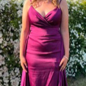 Lila balklänning från Abiyeniall - Elegant Lila långklänning med smala axelband och omlott-design. Klänningen har en v-ringad urringning och snörning i ryggen för en perfekt passform. Perfekt för speciella tillfällen. 💜Endast använd en gång så är i Ny skick!                       Öppen för prisförslag! ☺️