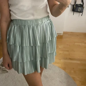 Grön plisserad kjol - Snygg grön plisserad kjol med volanger. Perfekt för en somrig look