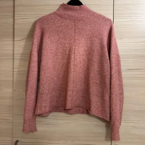 Rosa tjocktröja  - Mysig rosa stickad tröja med hög krage från NA-KD. Har som ”sömmar” längs med tröjan och tvärs över vid nederkanten på både fram och baksida av tröjan. Supermysig men kommer tyvärr inte till användning längre.