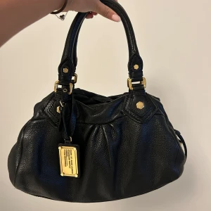 Marc jacobs väska - såå snygg väska från marc jacobs med gulddetaljer, långa bandet tillkommer!
